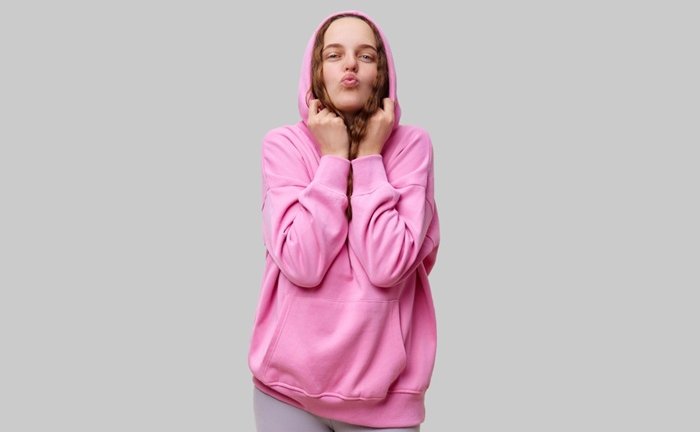 A,Young,Woman,Wearing,A,Bright,Pink,Hoodie,Playfully,Poses